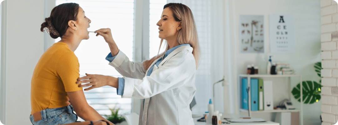 Doctor performing a oral exam on a female patient