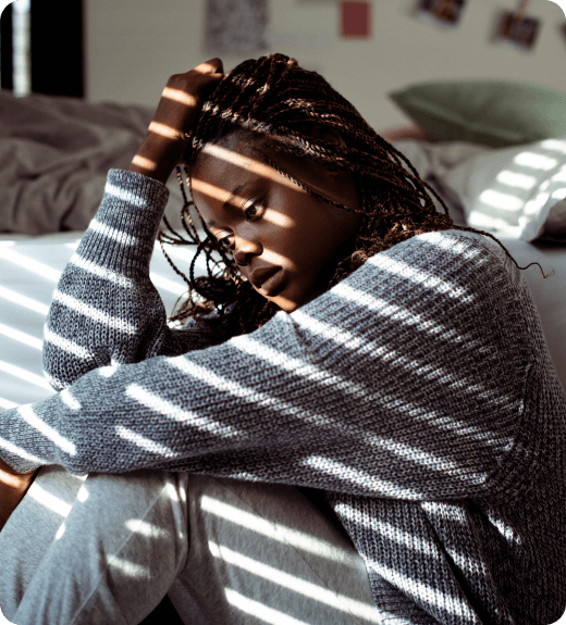 Woman sitting by the bed depressed