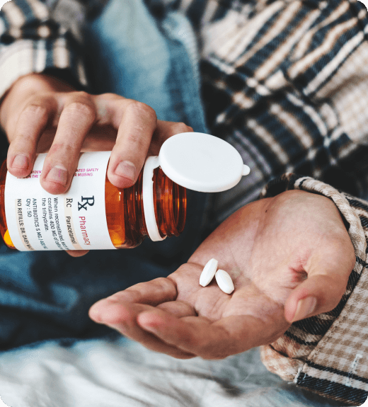 Man pouring opioid pills onto his hand