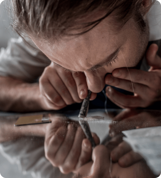 Woman snorting cocaine on glass table